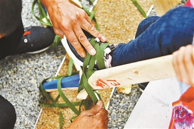 延庆区高跷协会工作人员为孩子绑木跷