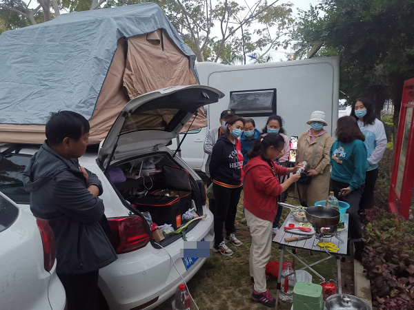 苏敏边做饭边直播，吸引了很多车友围观。