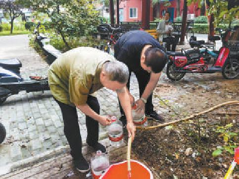 居民到临时接水点接水。
