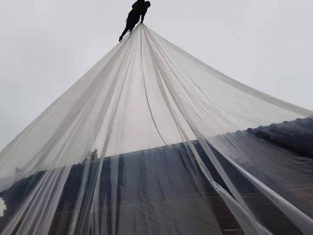 工作人员为全国重点保护文物龙兴寺大雄宝殿加盖雨布。图源：受访者供图