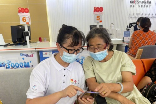 贵州联通六盘水分公司员工在帮助老年用户使用手机