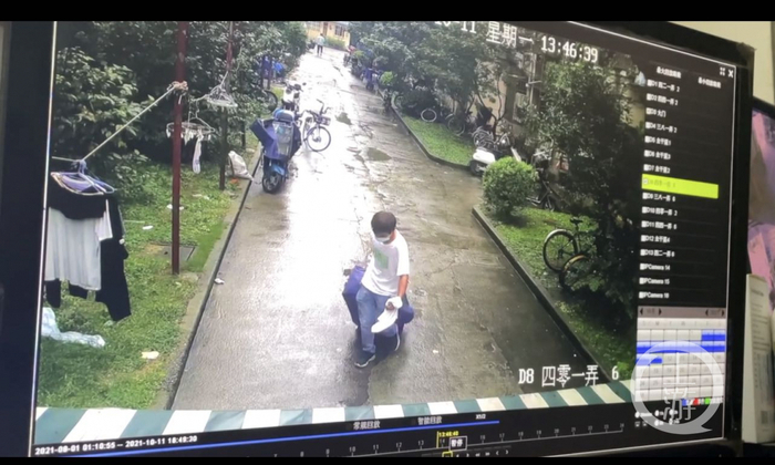  ▲网传视频中，一男子拉着行李箱离开案发小区。图片来源/视频截图