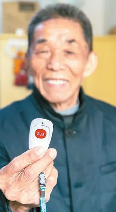 上海市闵行区新虹街道引入智慧化管理系统。图为新虹街道一名老人在家中展示紧急呼叫设备。新华社记者 王翔摄