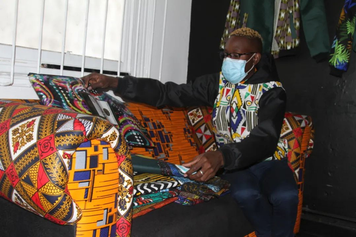 ▲2021年9月1日，西班达向记者展示用于制作服饰的非洲花布。新华社发（塔法拉·穆瓜拉摄）