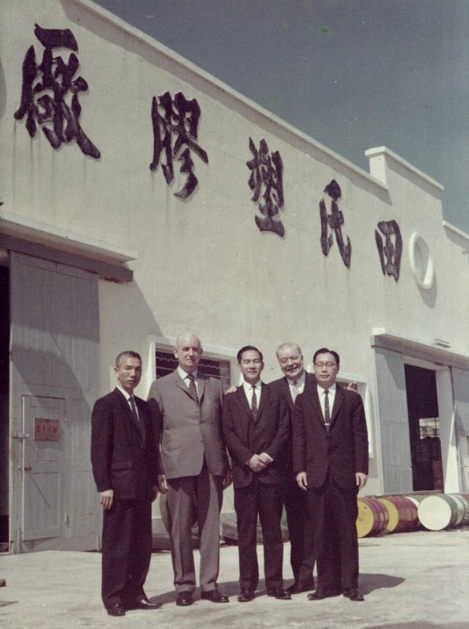 田家炳（左）在田氏塑胶厂房外留影（图片来源：香港商报网） 