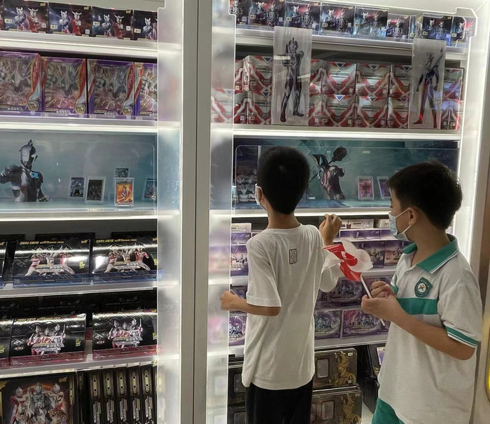 （在卡游超级旗舰店挑选商品的小学生 时代周报记者摄）