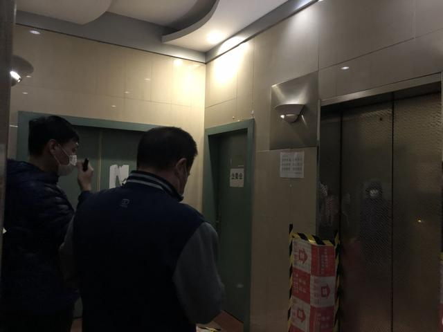 10月21日，业主站在2号楼的楼梯间内，电梯旁为业委会办公室大门。李欣然摄