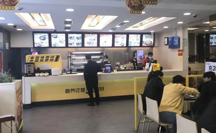△真功夫新金浦店前台点餐处，有“米饭免费续，小菜免费加”的公示牌。
