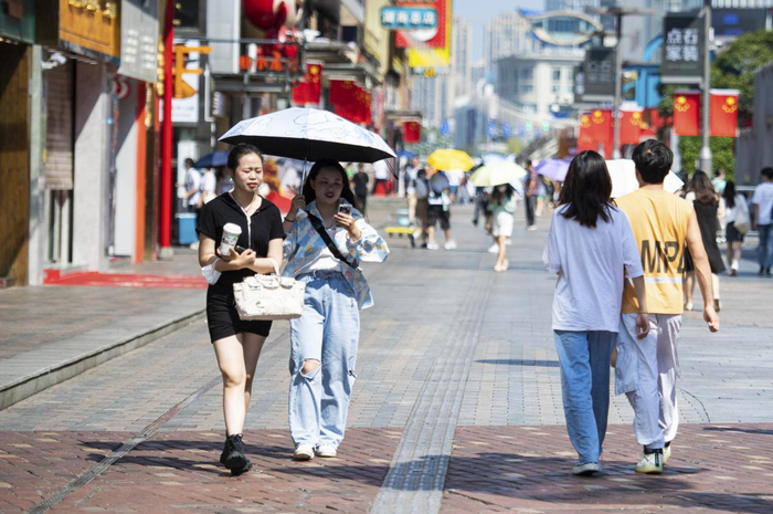 上图：湖南长沙刷新“最晚高温日”纪录，市民感慨“留给秋天的时间不多了”。图为10月4日，行人在湖南长沙黄兴路步行街打伞防晒。（新华社记者 陈思汗摄）