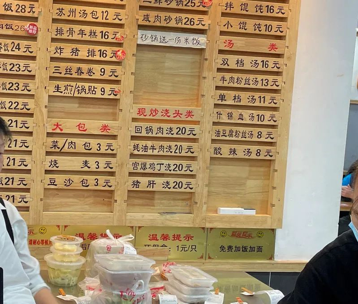 △老盛兴江宁一店进门处的菜单下方有“免费加饭加面”的提示。