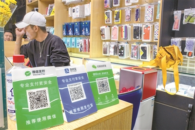 反垄断法（修正草案）立足执法实践，针对近年来社会各方面反映较多的“二选一”等问题作出专门规定，明确了相关行为是否构成垄断行为的判断标准，也让接入数字平台的小商户等有了更多的选择。图为支持多种支付方式的小商户。 图源：视觉中国