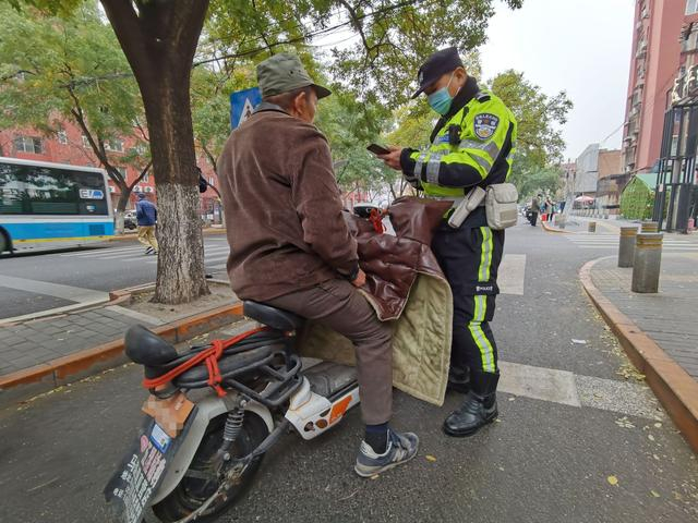 在太平桥东里小区门口，交警在查处违法上路的“超标电动车”。新京报记者 裴剑飞 摄