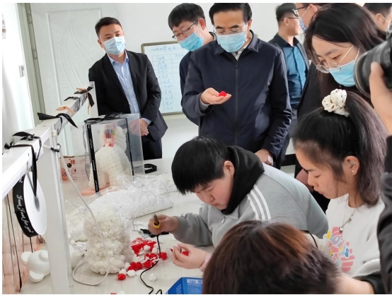 程凯副理事长查看残疾人手工作