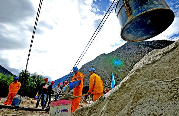 △藏中联网工程的施工人员正在使用索道，为R035号塔位运送水泥、沙子、石子等材料。