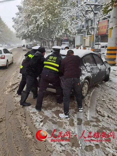 交警和路人一起帮助受困的车主。陈达摄