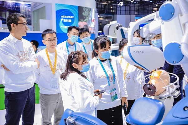 图说：植发手术辅助机器人吸引了乡村医生的目光