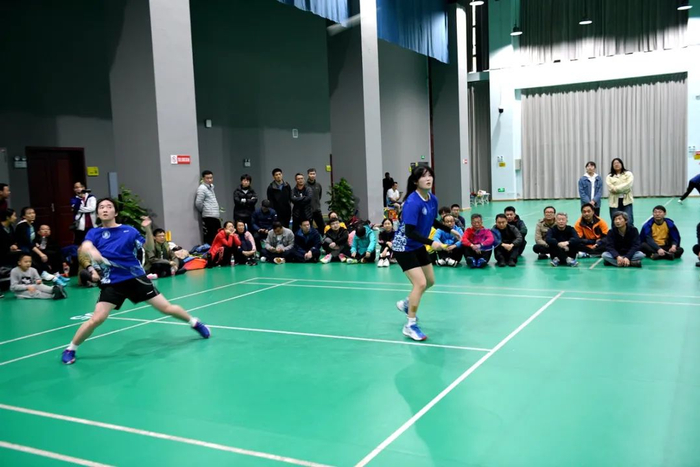 ▲表演赛上，学校高水平运动员陈姿霖（前场者）、申子萱学生组合奋力“迎战”（徐行 摄）