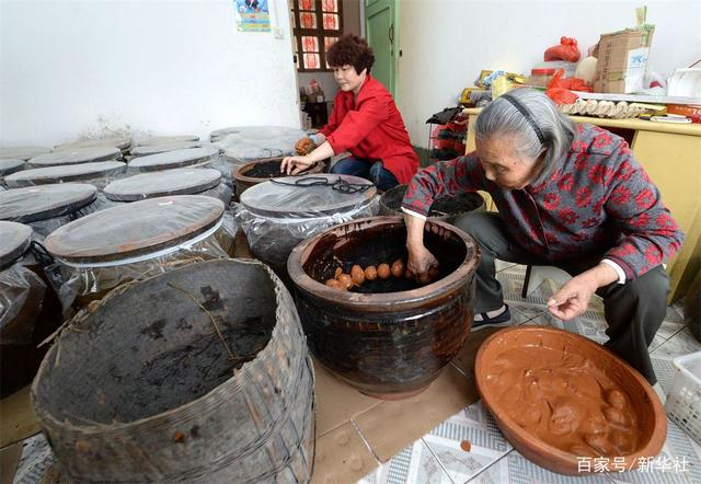 江西瑞金市壬田镇凤岗村村民廖秀英（右）在自己的咸鸭蛋合作社内腌制咸鸭蛋（2017年4月10日摄）。新华社记者 彭昭之 摄