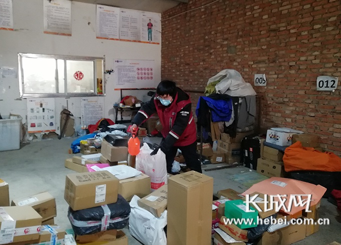 圆通速递石家庄北国商场网点的快递小哥李威正在对快递包裹进行消毒。