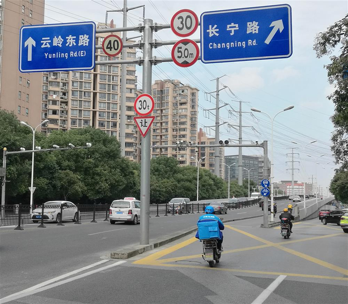 △泸定路桥的南北两端，则都挂设白框蓝色，内置自行车图案的圆形非机动车道指示标志，不过无“推行”标志。