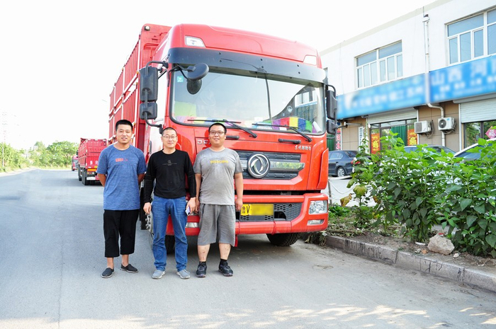 郑建华（中）与一起开着东风轻卡奋斗的同事们