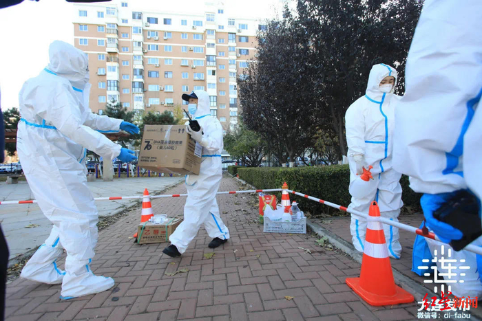 ▲工作人员为市民搬运物资 图据大连发布