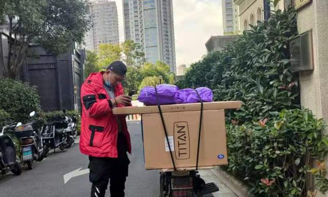 10月29日，王小山在送快递途中，用短信和收件人联系。新京报记者 陈亚杰 摄