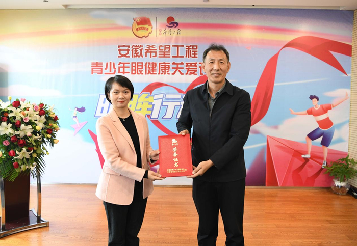             图：安徽省青少年发展基金会秘书长李永军向苏明娟颁发“爱眼大使”聘书