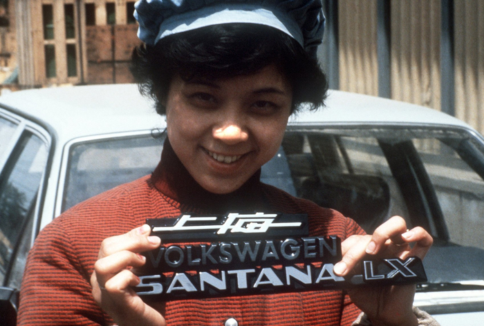 1985年，上海大众的女工举着桑塔纳的品牌标识 图源：视觉中国