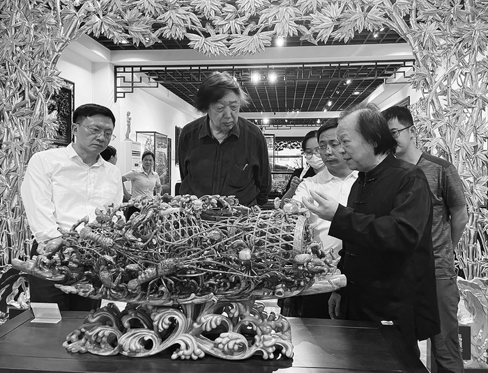     听辜柳希（右二）讲虾蟹篓的木雕制作    潮州日报记者 庄园 摄