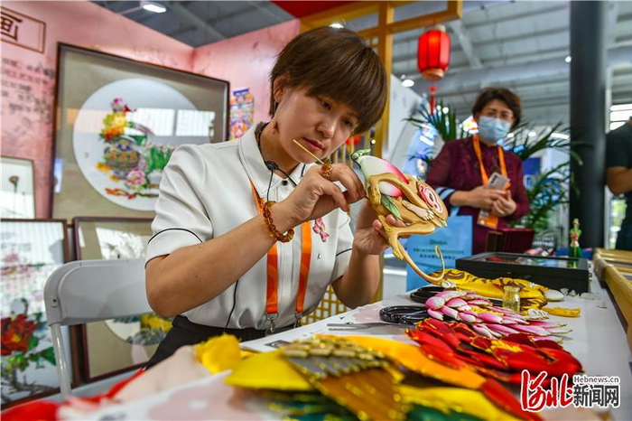 9月3日，中国国际服务贸易交流会首钢园文旅服务专题展2号馆，国家级非遗项目布糊画的传承人郝如香向观众展示布糊画的制作工序。 