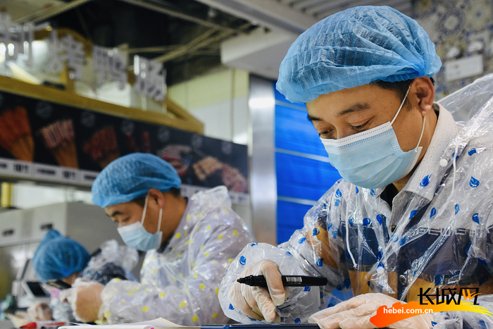 　商超工作人员查看线上订单情况。贾凡 摄