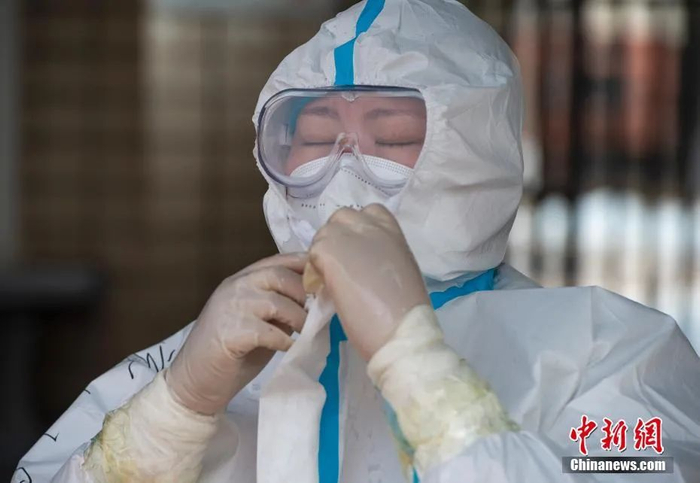 图为苏倩轮班休息前脱去防护装备。 中新社记者 侯宇 摄