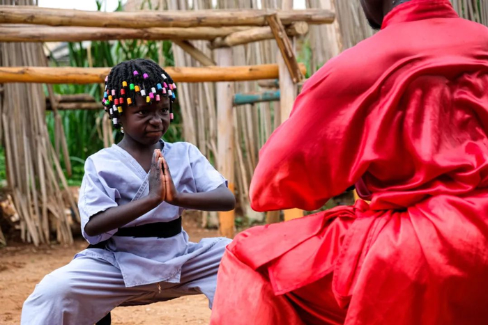 2021年8月23日，在乌干达瓦基索区的卡图克镇，武术教练基扎·玛尼苏鲁·塞吉姆巴正在教他的五岁女儿中国功夫。新华社发