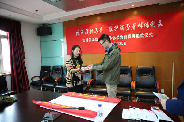 集体诉讼胜诉后，消费者从消协工作人员手中接到退款。李洪涛/摄