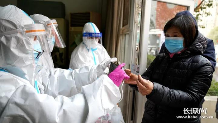 石家庄市鸿瑞小区核酸检测现场，医护人员拍照将居民身份信息录入系统。长城网记者 冯硕 摄