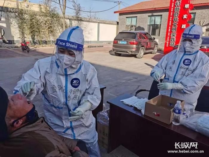 黄晓洁（左）与潘伟（右）结组进行核酸采集。