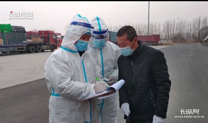 工作人员为邢台运输车辆司机登记信息、测量体温。视频截图