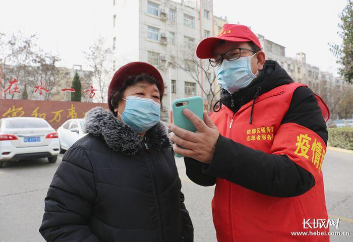 王现军手把手教小区里的居民线上买菜。杜媛 摄