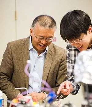  ·陈刚（左）指导学生做实验。