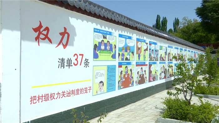 图为玉门市利用乡村文化墙，以漫画的形式，向村组农户广泛宣传“玉门市村级权力清单37条”，进一步提升群众知晓率。
