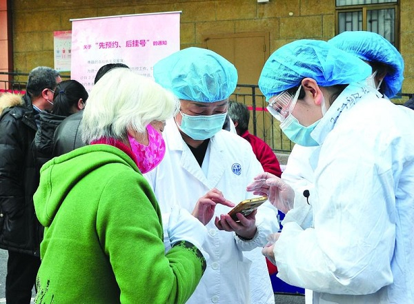 图说：老年患者不擅长使用手机预约就医，仁济医院医护人员在院门外现场指导预约方法 通讯员 杨建正/摄