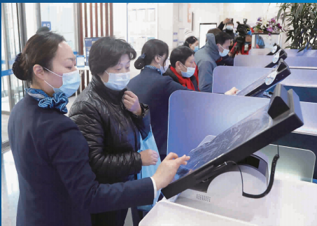 图说：上海银行工作人员指导老人使用自助服务系统 新民晚报记者 王凯/摄