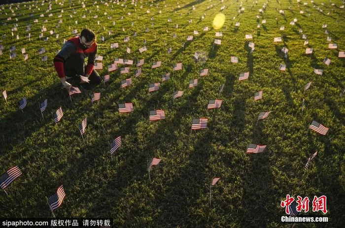 资料图：2020年9月21日，美国华盛顿，志愿者在国家广场上放置2万面美国国旗，纪念新冠疫情里死亡的近20万人。图片来源：Sipaphoto版权作品 禁止转载