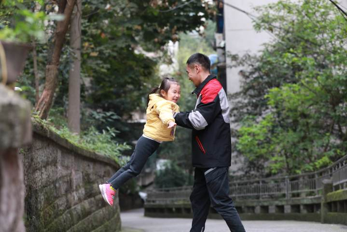 重庆快递小哥黄厚强，每天最快乐的时光就是和小棉袄在一起。视觉中国 供图