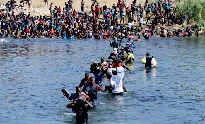 ▲ 2021 年9月19日，购买物资的非法移民往返于美墨边境的里奥格兰德河上摄影 / 本刊