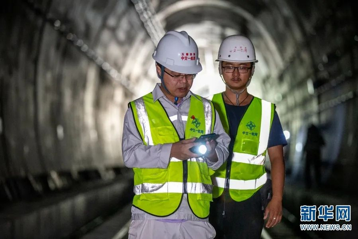 吕红军（左）在景寨隧道内查看收尾工作（摄于10月26日）。赵普凡 摄