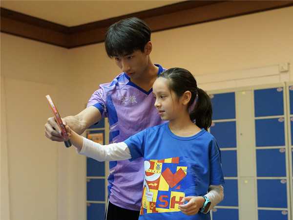 图说：管文涛指导欧君廷的女儿握拍。采访对象供图