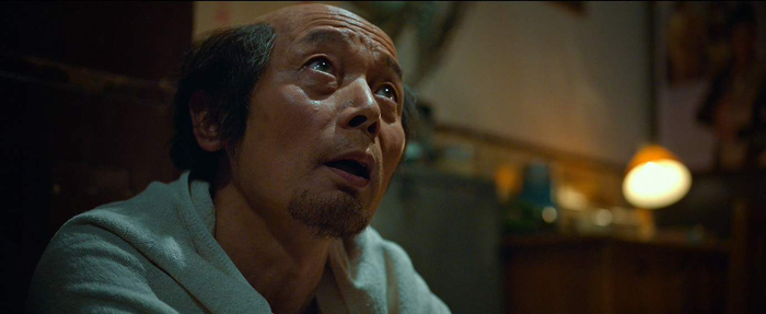 《古董局中局》预告片截图。葛优饰演的付贵留着“地中海发型”。