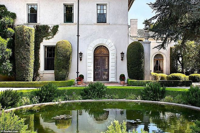 图2：这栋白色的七卧七卫住宅被美丽的绿色植物包围着，可以沿着内部小路漫步其中